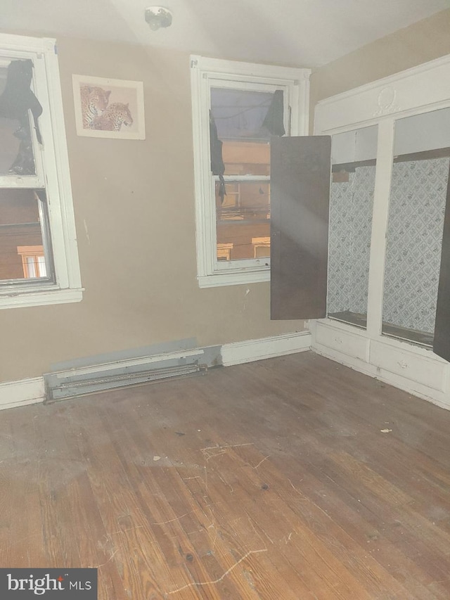 unfurnished room featuring hardwood / wood-style flooring and a baseboard radiator