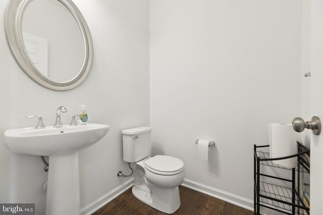 bathroom featuring hardwood / wood-style flooring and toilet