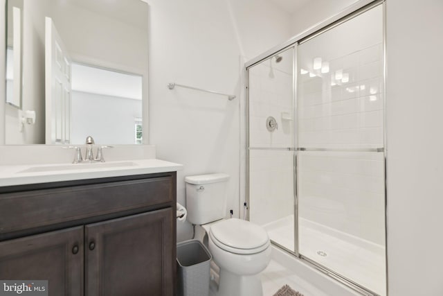 bathroom featuring vanity, toilet, and a shower with shower door