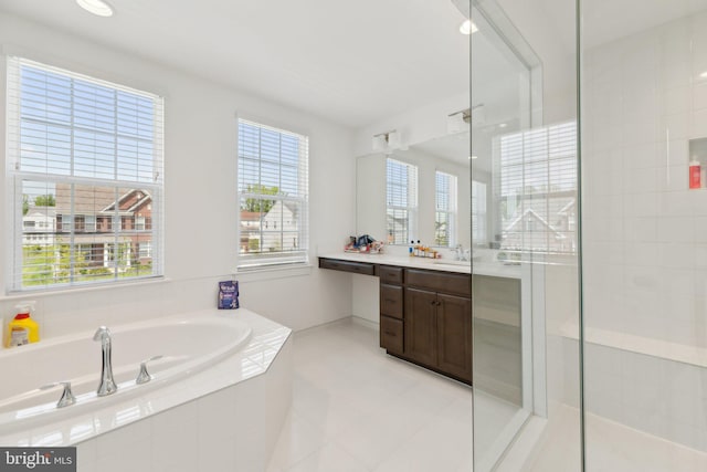 bathroom featuring plus walk in shower, vanity, and tile patterned floors