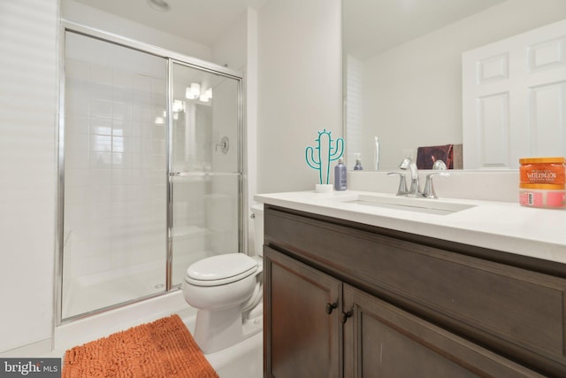 bathroom featuring vanity, toilet, and a shower with door