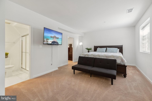 bedroom with light colored carpet and ensuite bath