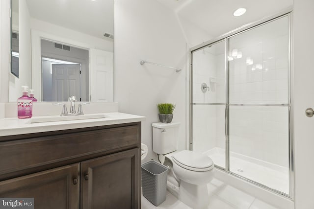 bathroom featuring toilet, vanity, tile patterned floors, and a shower with shower door