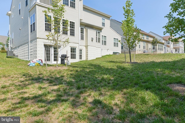 rear view of property featuring a yard and central AC