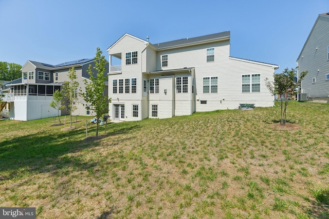 back of property featuring a lawn and central AC unit