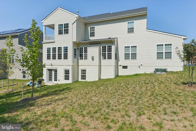 back of property with a balcony and a yard