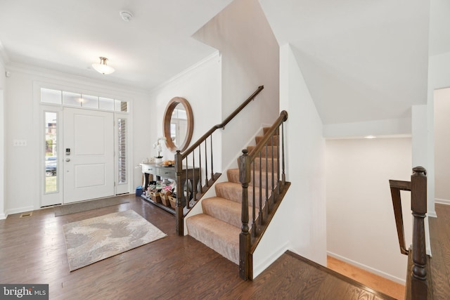 foyer entrance with dark hardwood / wood-style flooring, crown molding, and a wealth of natural light