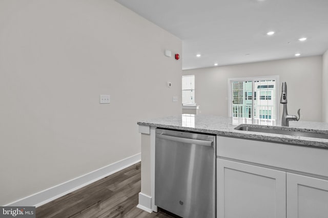 kitchen featuring light stone counters, dark wood-type flooring, sink, dishwasher, and white cabinetry