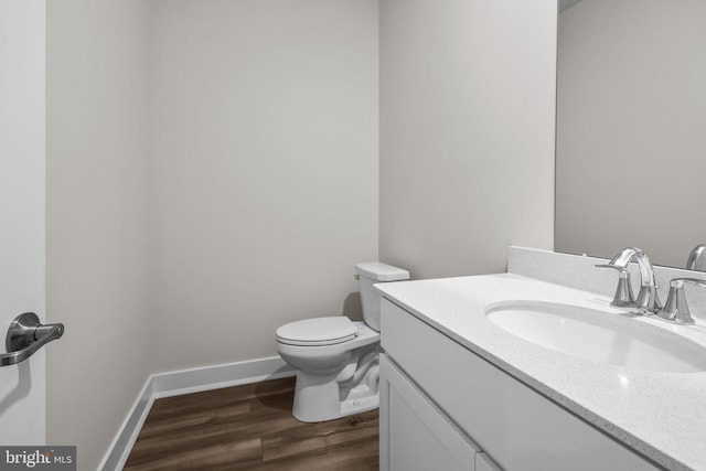 bathroom with vanity, toilet, and wood-type flooring