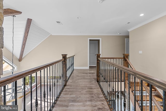 hallway with hardwood / wood-style floors, lofted ceiling, and crown molding