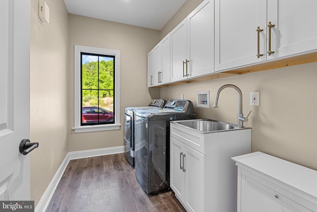 washroom featuring sink, cabinets, dark wood-type flooring, and washing machine and dryer