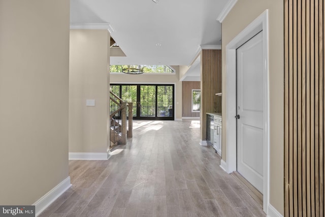 corridor with a chandelier, light hardwood / wood-style flooring, and crown molding