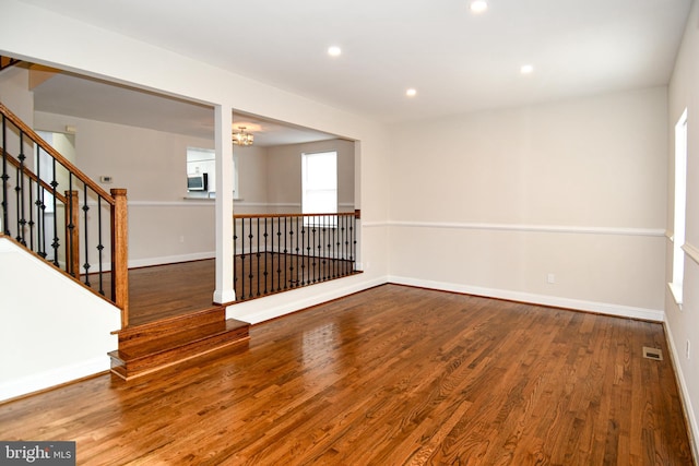 unfurnished room with a chandelier and wood-type flooring