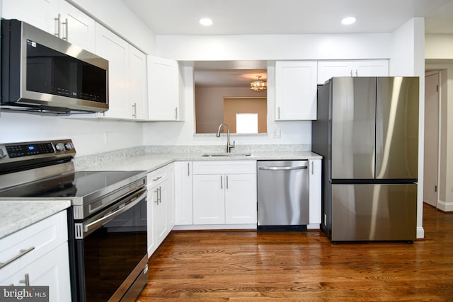 kitchen with sink, dark hardwood / wood-style flooring, light stone counters, white cabinetry, and stainless steel appliances