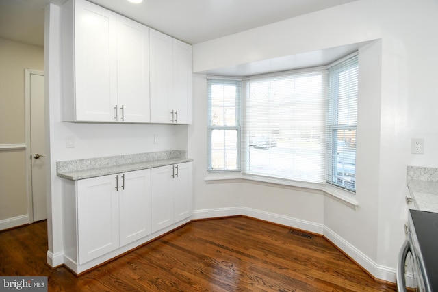 unfurnished dining area featuring dark wood-type flooring