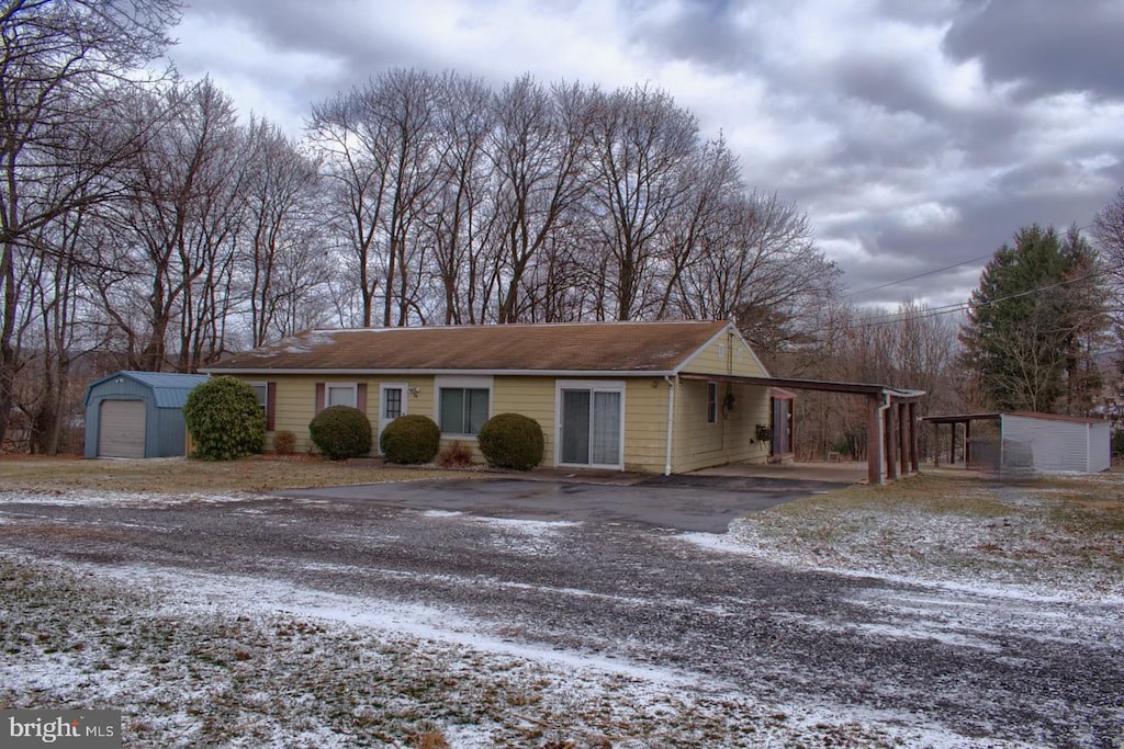 view of front facade featuring a carport, a garage, and an outdoor structure