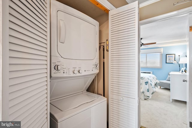 laundry room featuring carpet flooring, ceiling fan, and stacked washer / dryer