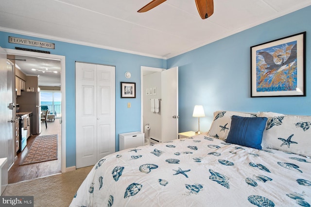 bedroom featuring ceiling fan, carpet floors, crown molding, and a closet