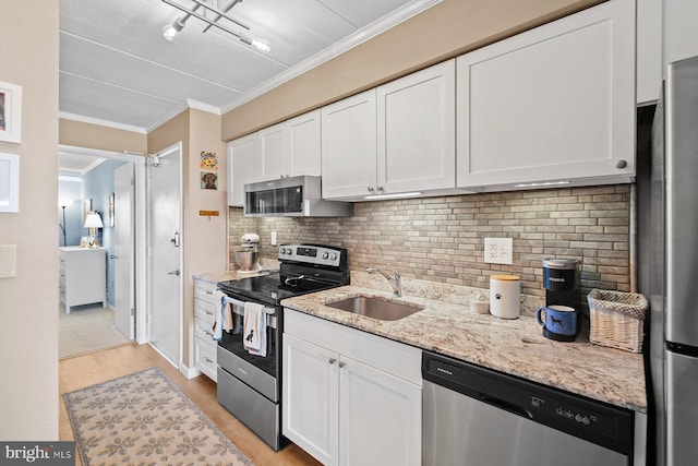 kitchen featuring light stone countertops, white cabinetry, sink, stainless steel appliances, and decorative backsplash