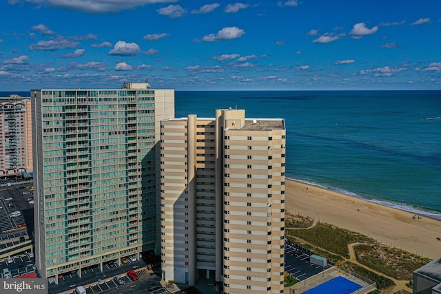 birds eye view of property with a water view and a beach view