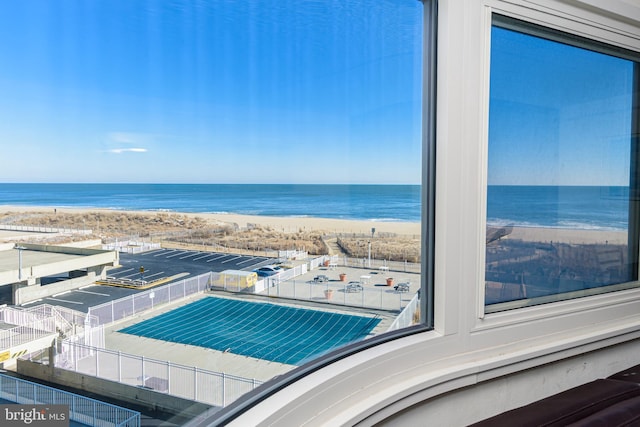 view of swimming pool featuring a water view and a beach view