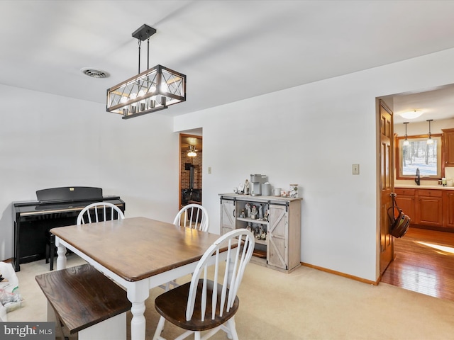 dining room with light colored carpet and sink