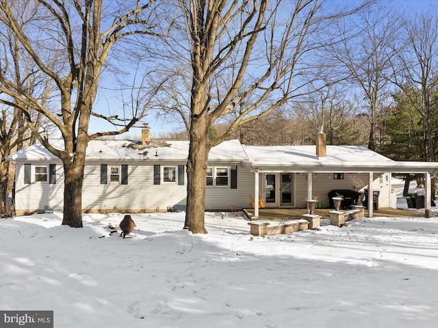 snow covered house with a carport