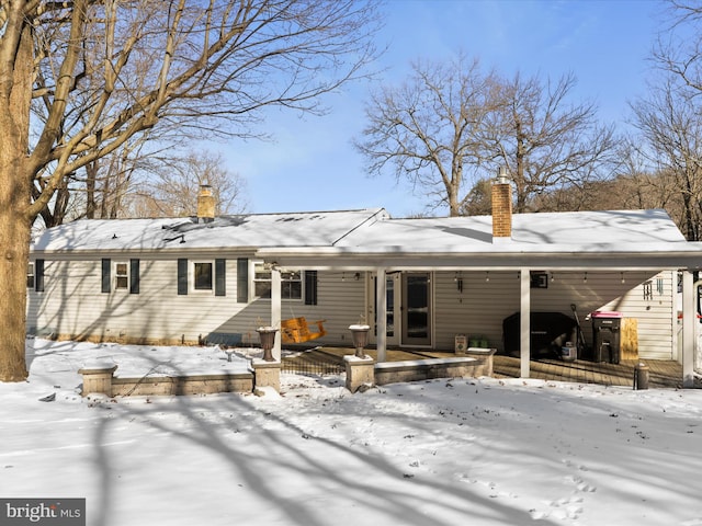 view of snow covered rear of property