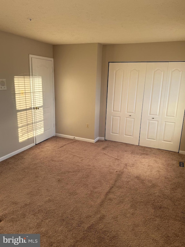 unfurnished bedroom with light carpet and a closet