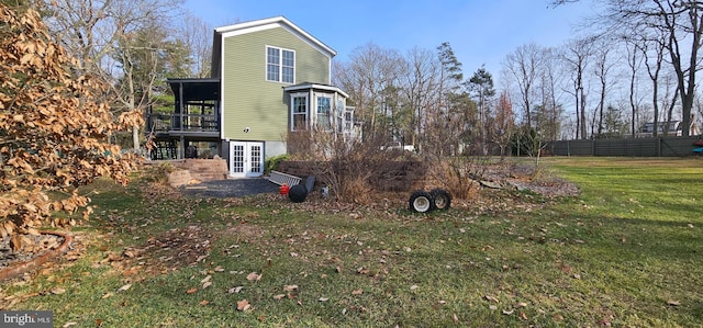 rear view of property featuring french doors and a lawn