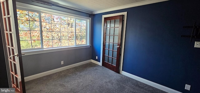 empty room featuring carpet flooring, crown molding, and a wealth of natural light