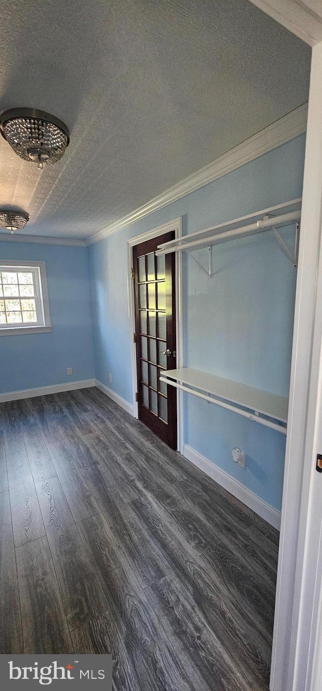 spare room featuring a textured ceiling, dark hardwood / wood-style flooring, and crown molding