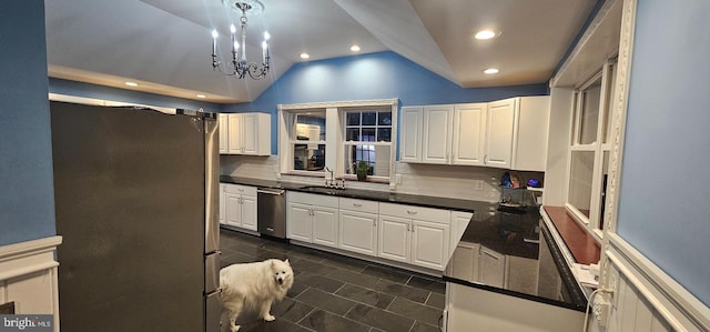 kitchen featuring lofted ceiling, sink, decorative backsplash, appliances with stainless steel finishes, and white cabinetry