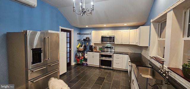 kitchen featuring stainless steel appliances, sink, an inviting chandelier, white cabinetry, and lofted ceiling