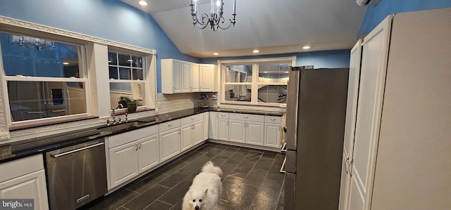 kitchen with white cabinets, sink, vaulted ceiling, appliances with stainless steel finishes, and tasteful backsplash