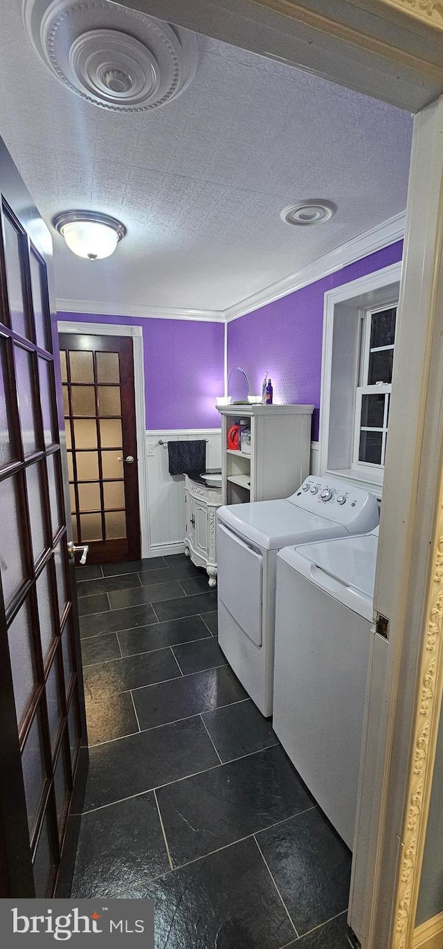 clothes washing area featuring cabinets, independent washer and dryer, and ornamental molding