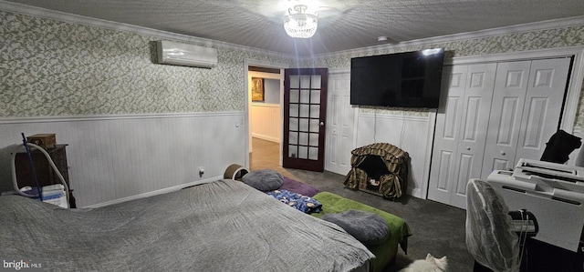 carpeted bedroom featuring a closet, crown molding, and a wall mounted AC