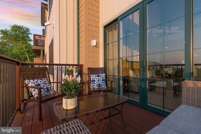 balcony at dusk featuring french doors