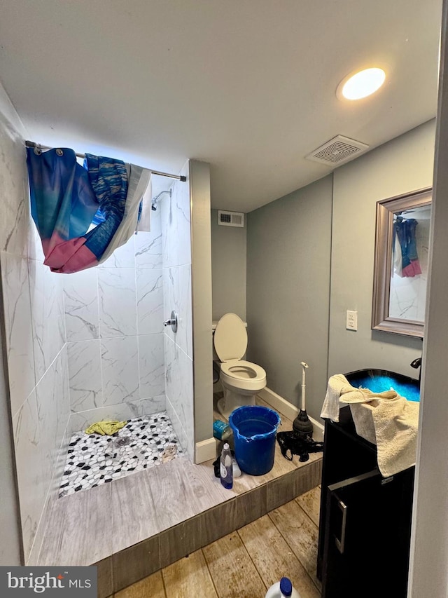 507 N Loudon Ave, Baltimore, MD 21229 - bathroom with wood finished floors, tiled shower, and vanity