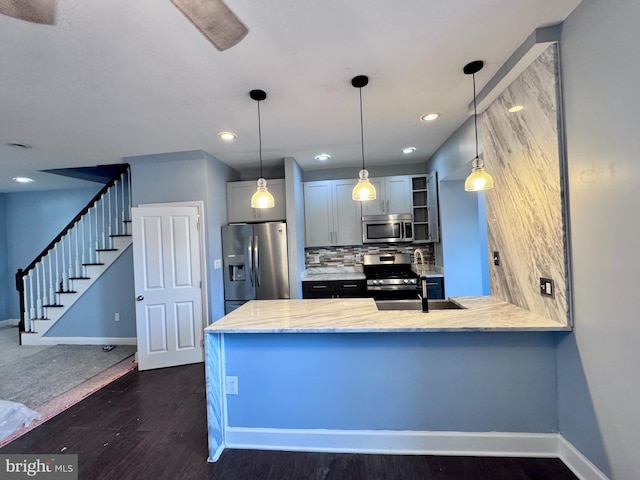 507 N Loudon Ave, Baltimore, MD 21229 - kitchen with appliances with stainless steel finishes, dark wood-style flooring, a peninsula, hanging light fixtures, and backsplash