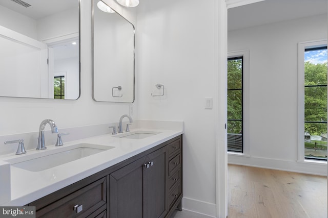 913 Drexel Ln, Bryn Mawr, PA 19010 - bathroom featuring wood finished floors, baseboards, and double vanity