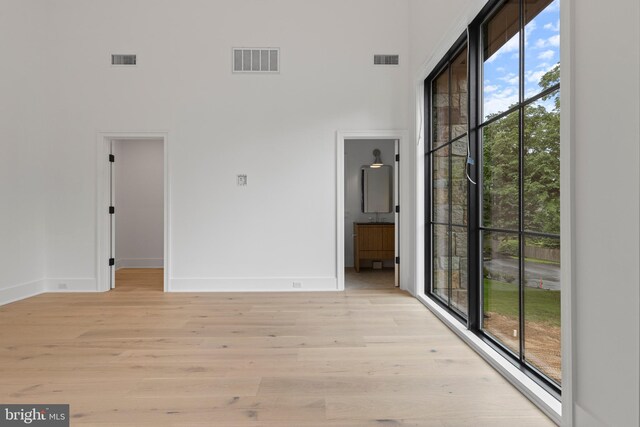 913 Drexel Ln, Bryn Mawr, PA 19010 - empty room featuring baseboards, light wood-type flooring, and a towering ceiling