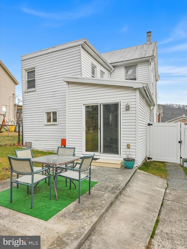 rear view of property featuring a yard and a patio