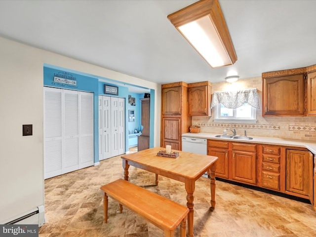 kitchen with white dishwasher, backsplash, sink, and a baseboard heating unit