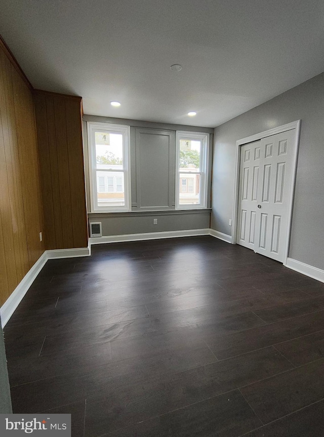 unfurnished bedroom featuring wooden walls