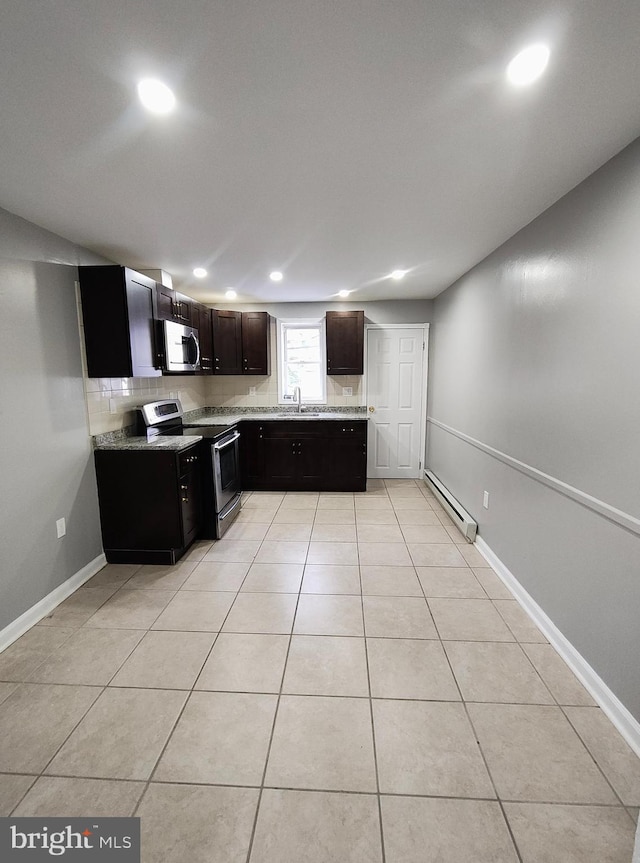 kitchen with sink, stainless steel appliances, a baseboard radiator, tasteful backsplash, and light tile patterned floors