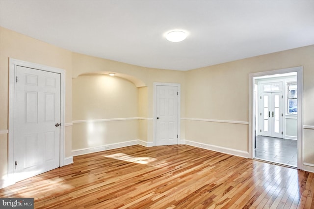 empty room with hardwood / wood-style floors and french doors