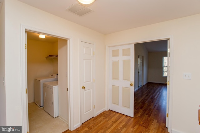 hallway featuring wood-type flooring and independent washer and dryer