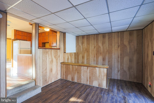 bar with dark wood-type flooring and white refrigerator