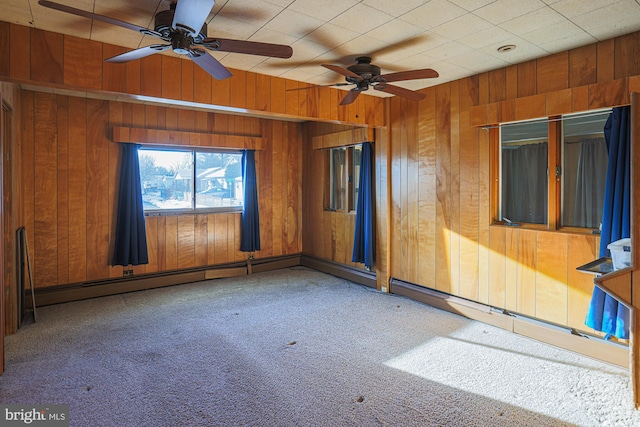 unfurnished room with wood walls, ceiling fan, and carpet flooring